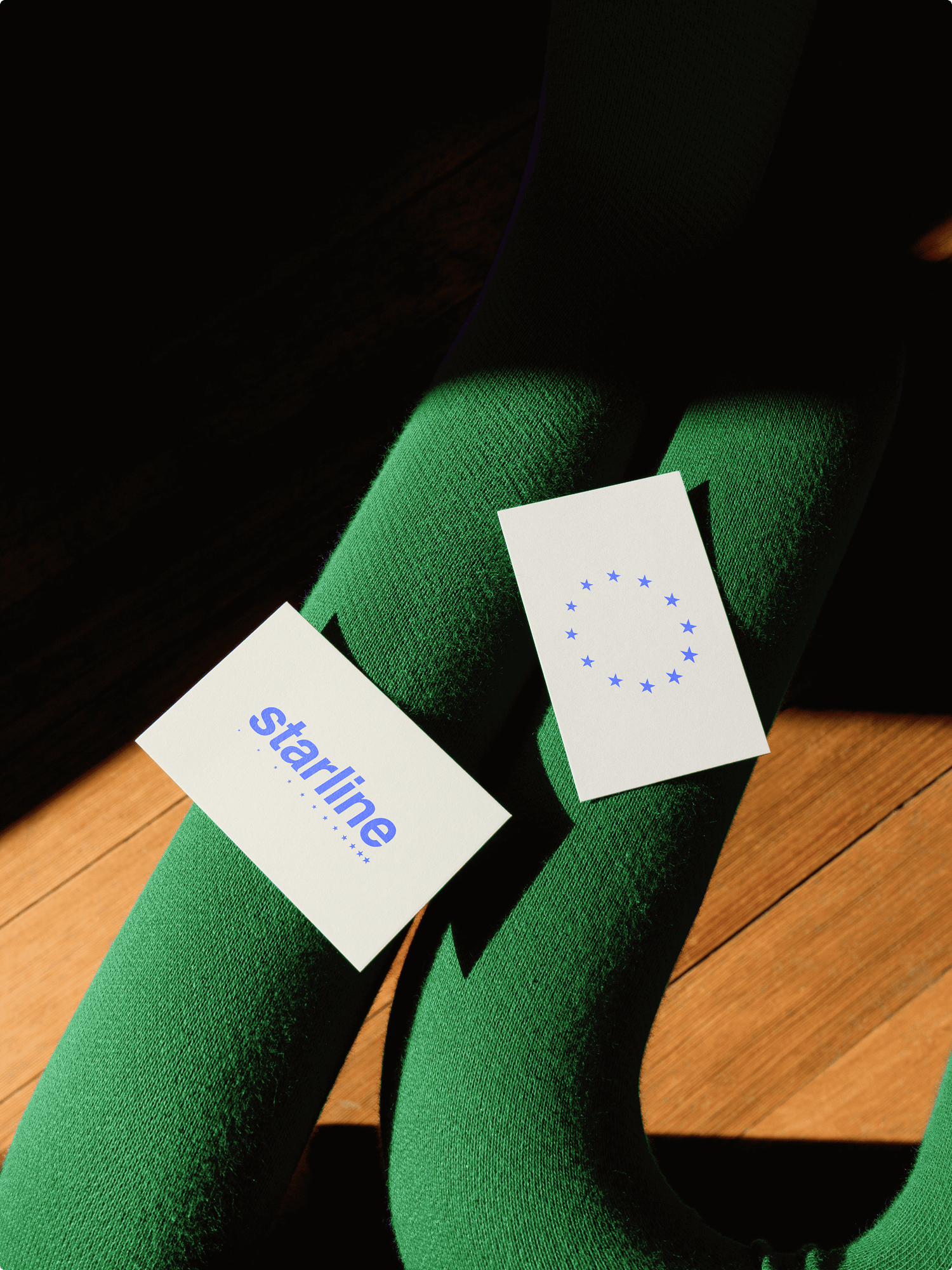 Mock up of business card, showing the starline logo, on a green chair in the sun