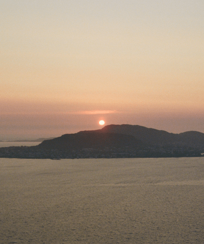 A sunset in Alesund, Norway. The sun almost disappears behind the mountains on an island