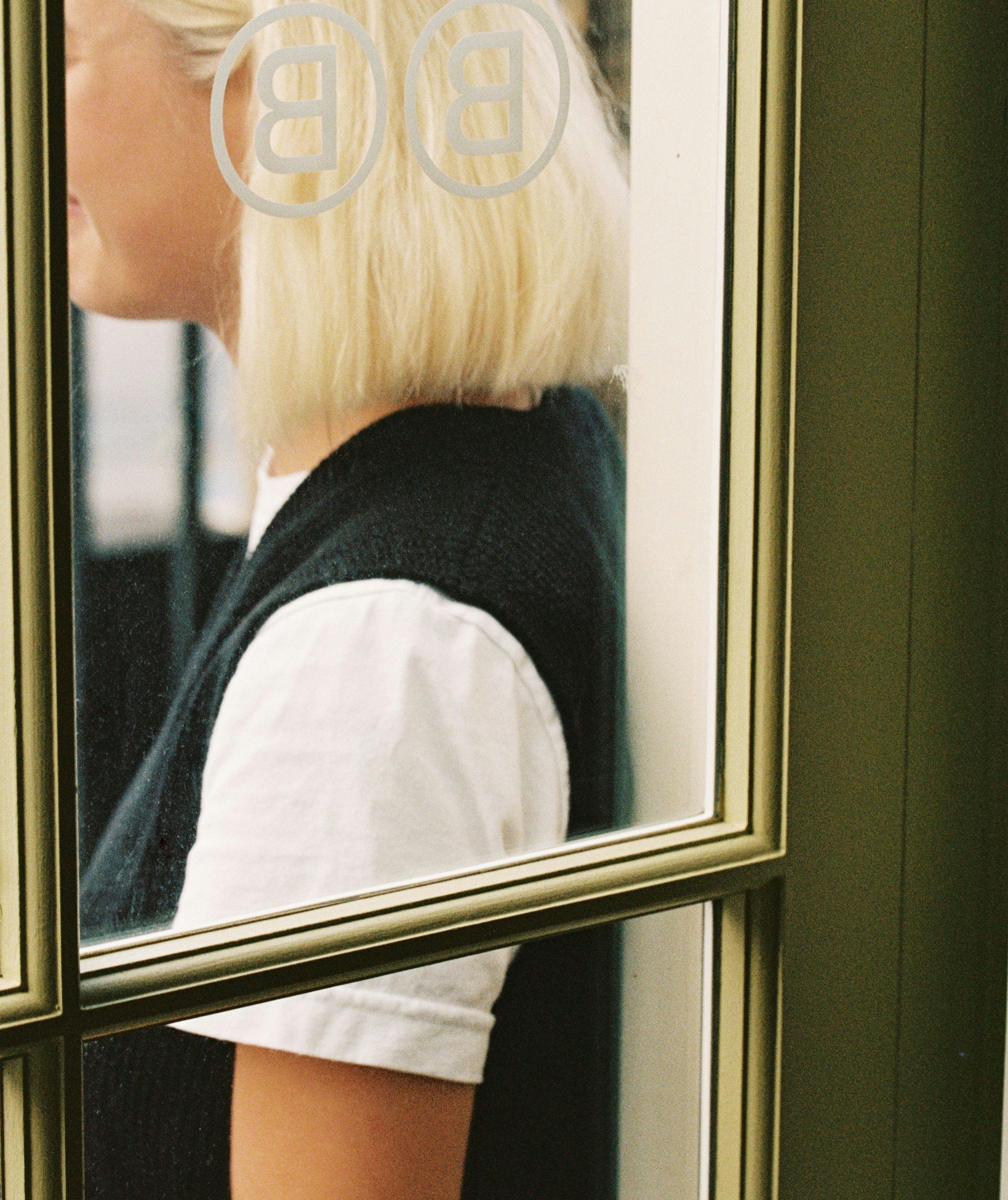 Blonde woman seen through a window