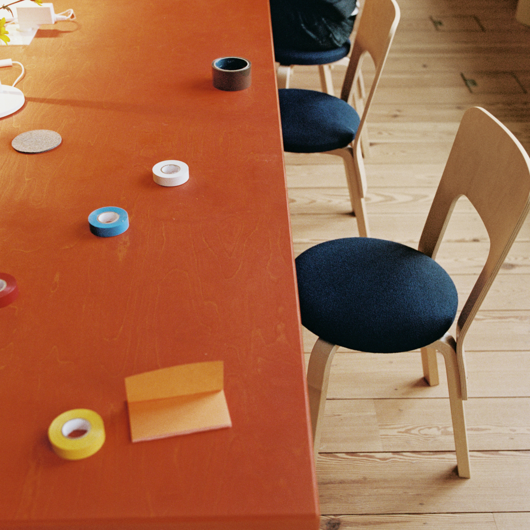 An orange table with stationery accessories and chairs