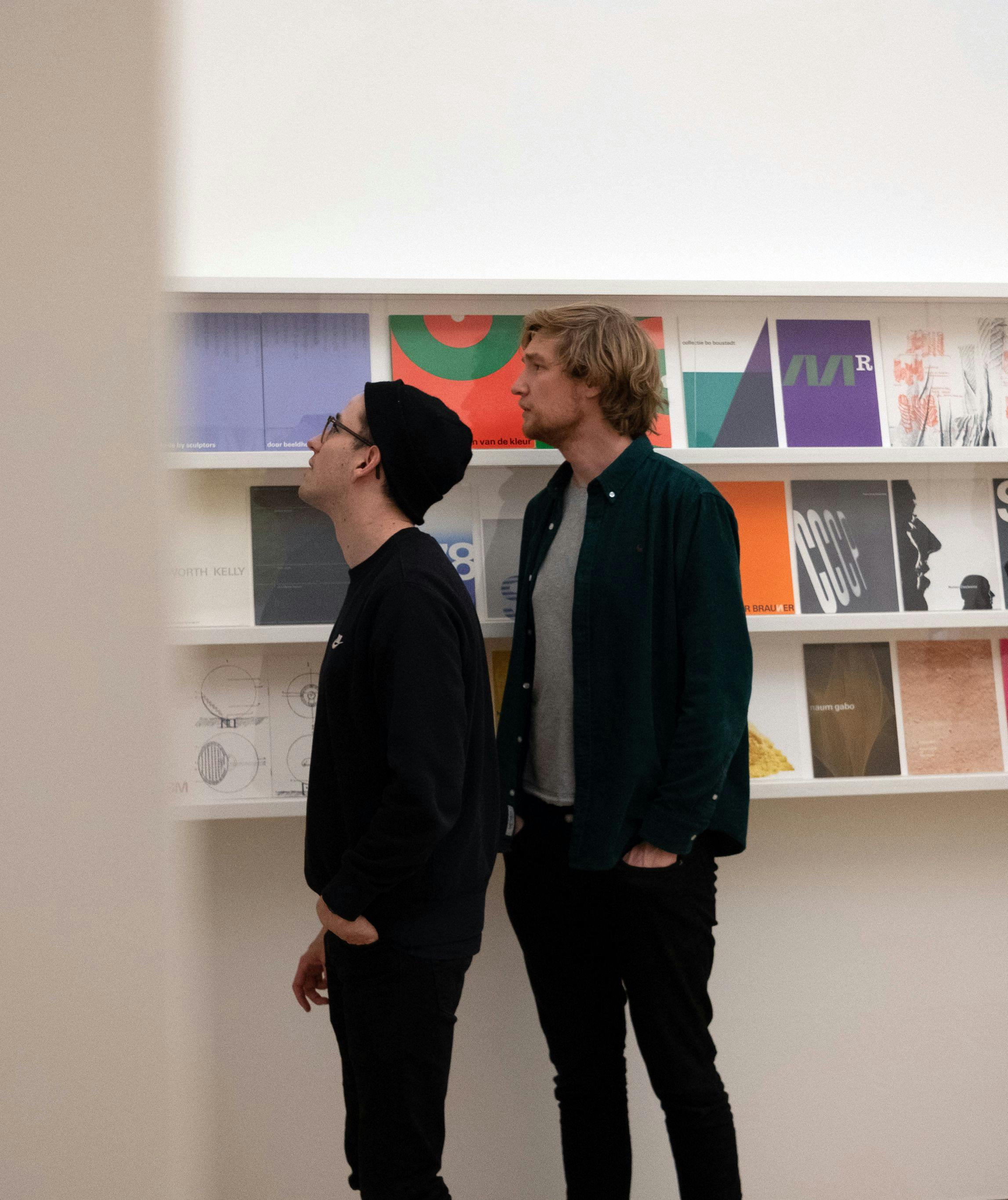 Two men standing in front of book shelves