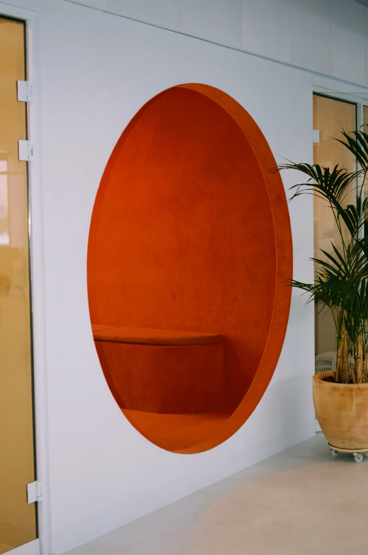 An orange meeting room seen from the hallway