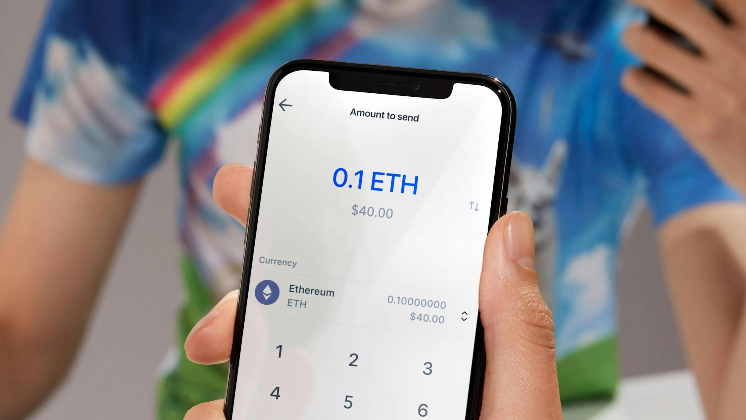 A person holding up a mobile phone with the Coinbase app open
