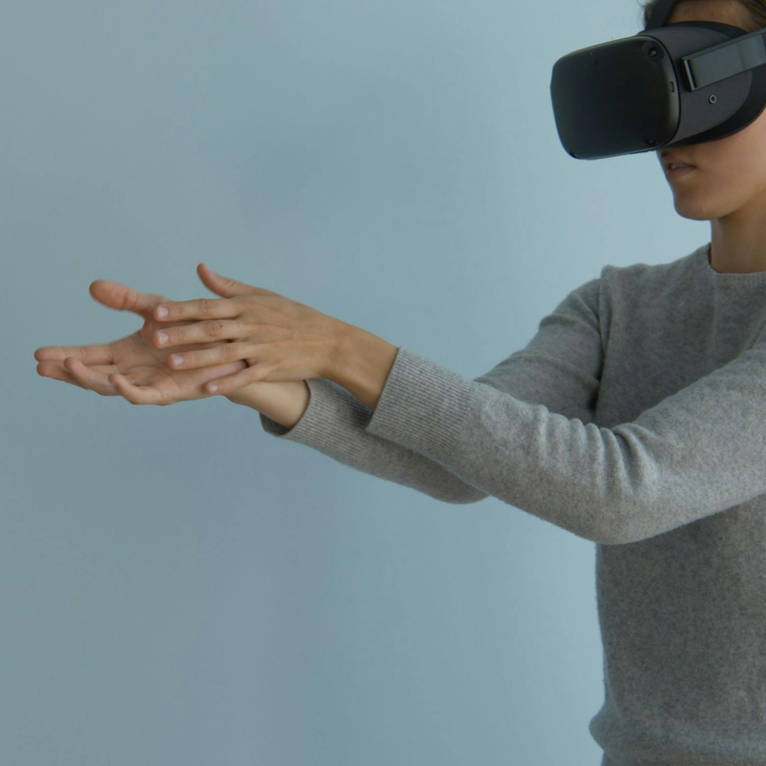 A woman moving her hands and wearing a Head-Mounted Display