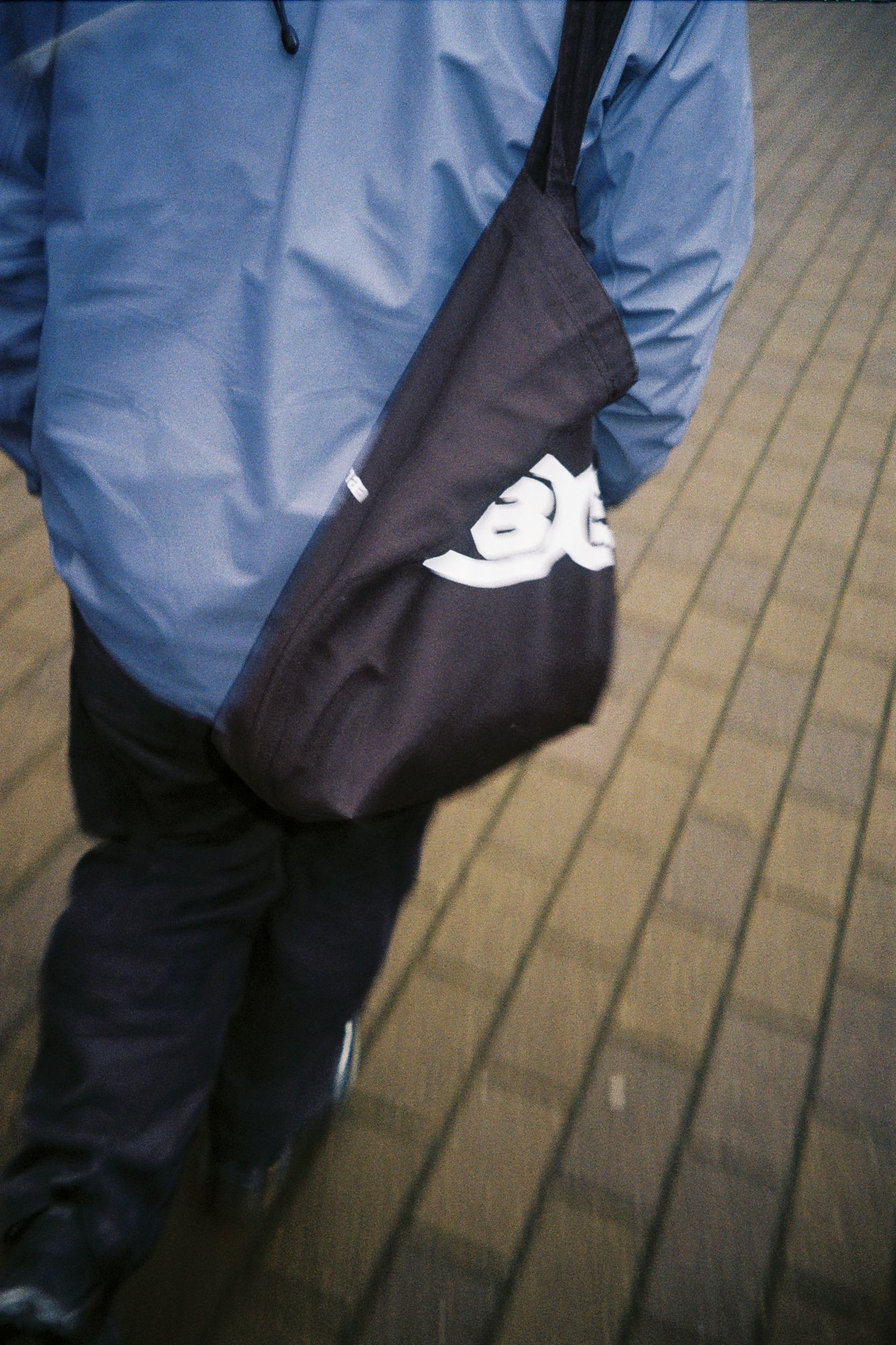 An image of a person wearing a blue jacket and a customised black fabric bag